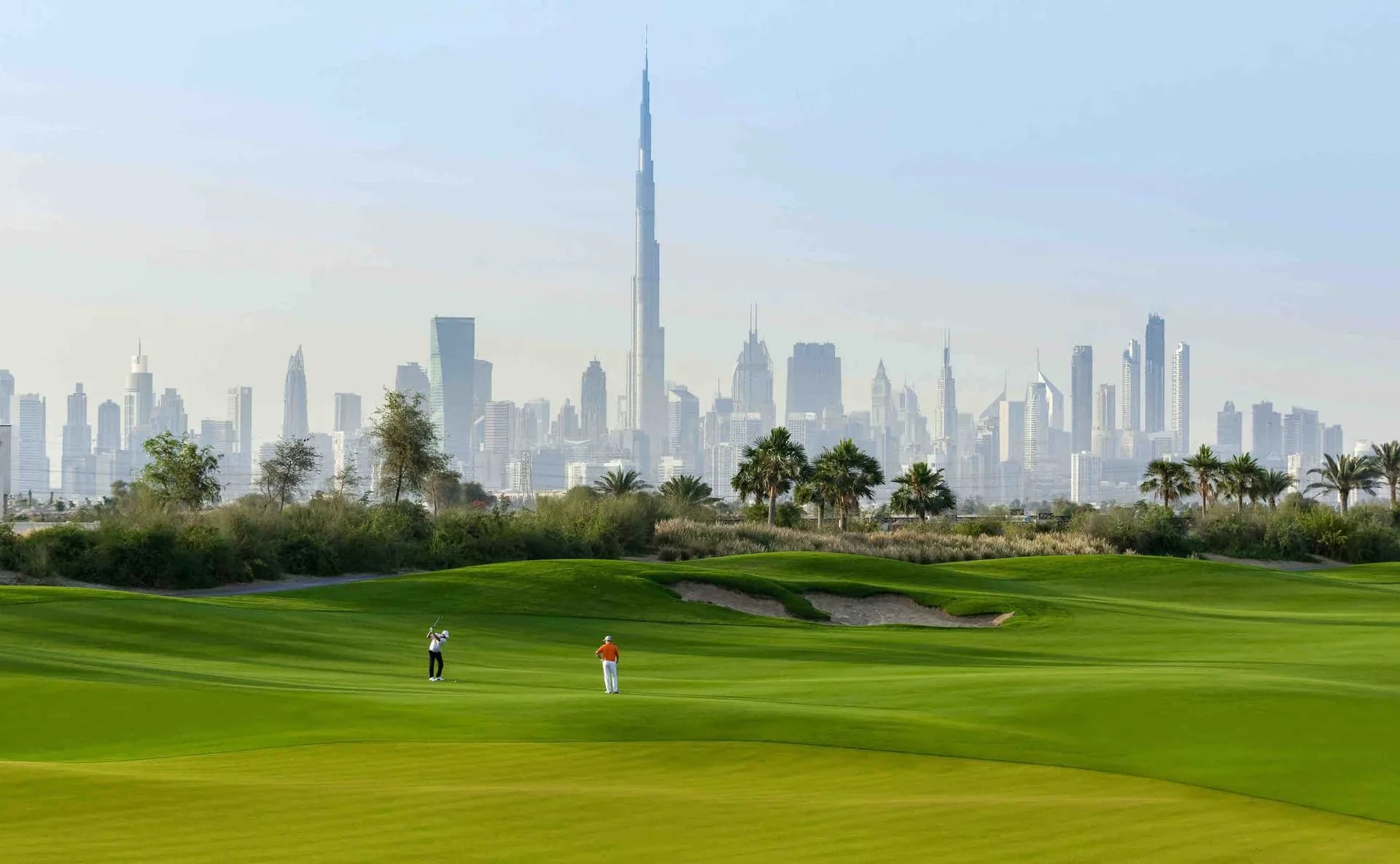 The Dubai Hills Golf Club fairway with the Burj Khalifa and the Downtown Dubai skyline on the horizon